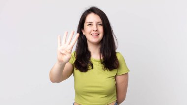 Güzel bir kadın gülümsüyor ve arkadaş canlısı görünüyor, dört ya da dört numarayı gösteriyor, eli önde, geriye doğru sayıyor.