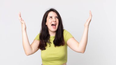 Güzel bir kadın kendini mutlu, şaşkın, şanslı ve şaşırmış hissediyor. Zaferi kutlarken iki eli havada.