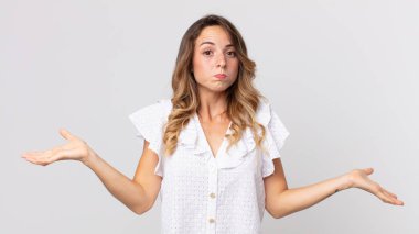 Kafası karışmış, kafası karışmış ve stresli görünen, farklı seçenekleri merak eden, belirsiz hisseden oldukça zayıf bir kadın.