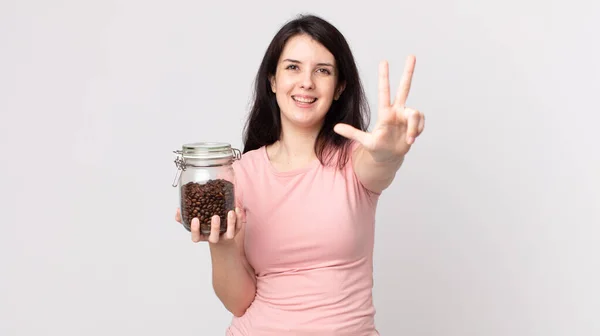 Pretty Woman Smiling Looking Friendly Showing Number Three Holding Coffee — Stock Photo, Image