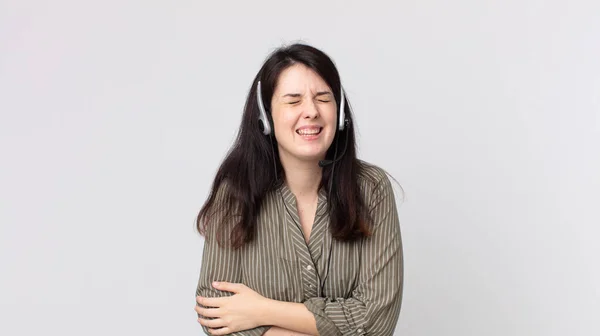 一个漂亮的女人在笑话中放声大笑 带耳机的助理探员 — 图库照片