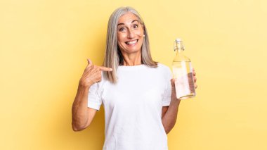 Mutlu, şaşkın ve gururlu hissediyorum. Heyecanlı, şaşkın bakışlarla ve elinde bir su şişesi tutarak kendimi işaret ediyorum.