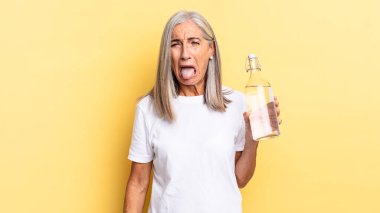 Neşeli, kaygısız, asi tavrıyla, şakalaşıp, dil çıkararak, eğlenerek ve su şişesini tutarak