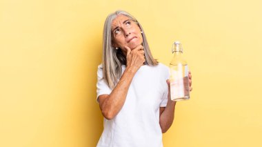 Düşünüyorum, kuşkulanıyorum ve kafam karışık, farklı seçeneklerim var, hangi kararı vereceğimi ve su şişesini tutacağımı merak ediyorum.