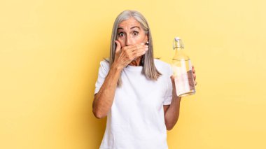 Şok olmuş, şaşırmış bir ifadeyle ağzı kapamak, bir sır saklamak ya da 