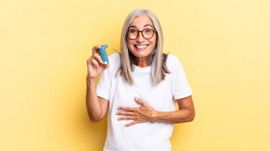 Komik bir şakaya yüksek sesle gülerek, mutlu ve neşeli hissederek, eğlenerek. astım konsepti