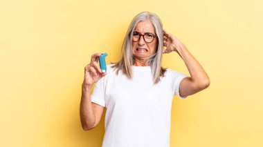 Stresli, endişeli, endişeli ya da korkmuş hissediyorum. Elleri başımda, hata yaptığımda panikliyorum. astım konsepti