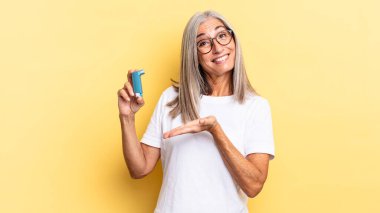 Neşeli bir şekilde gülümseyen, mutlu hisseden ve fotokopi uzayında avucunun içinde bir konsept gösteren. astım konsepti