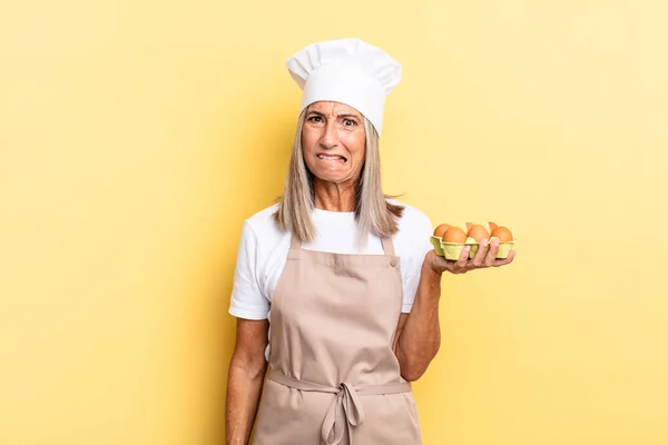 Mulher Chef Meia Idade Olhando Confuso Confuso Mordendo Lábio Com — Fotografia de Stock