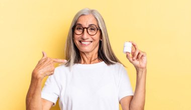 Mutlu, şaşkın ve gururlu hissediyorum. Heyecanlı, şaşkın bakışlarla ve elinde bir hap şişesi tutarak kendimi işaret ediyorum.