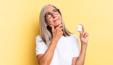 Düşünüyorum, kuşkulanıyorum ve kafam karışık, farklı seçeneklerim var, hangi kararı vereceğimi ve ilaç şişesini elimde tutacağımı merak ediyorum.