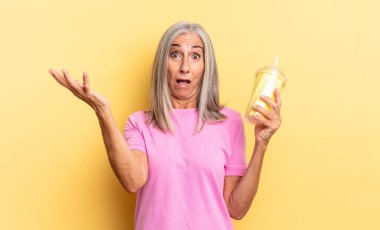 Son derece şok olmuş, şaşırmış, endişeli ve paniklemiş hissediyorum. Stresli ve dehşetli bir bakışla ve elimde bir milkshake tutarak.