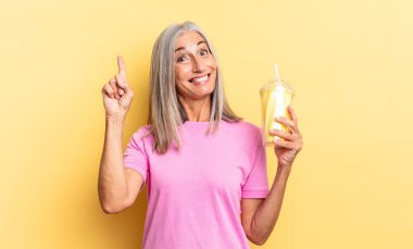 Bir fikri fark ettikten sonra mutlu ve heyecanlı bir dahi gibi hissetmek, neşeli bir şekilde parmak kaldırmak, eureka! Ve bir milkshake tutuyor.