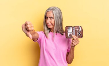 Kızgın, kızgın, sinirli, hayal kırıklığına uğramış ya da hayal kırıklığına uğramış, parmaklarını göstermeyen, elinde çivi alet çantası tutan biri.