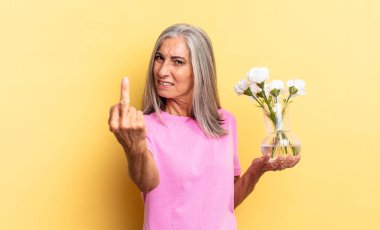 Kızgın, sinirli, isyankar ve agresif hissediyorum. Orta parmağımı şıklatıyorum. Dekoratif çiçekleri tutarak karşılık veriyorum.