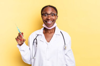 Mutlu ve hoş bir şekilde şaşırmış görünüyor, büyülenmiş ve şok olmuş bir ifadeyle heyecanlanıyor. Hekim ve şırınga kavramı