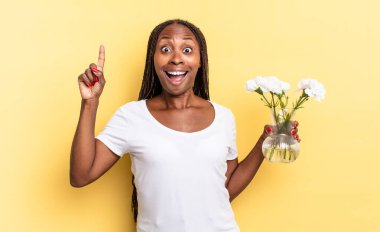 Bir fikri fark ettikten sonra mutlu ve heyecanlı bir dahi gibi hissetmek, neşeli bir şekilde parmak kaldırmak, eureka! Dekoratif çiçek konsepti