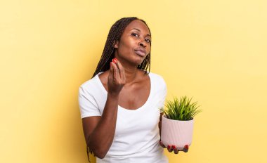 Kapiş ya da para hareketi yaparak, borçlarını ödemeni söyleyerek! Elinde bir saksı vardı.
