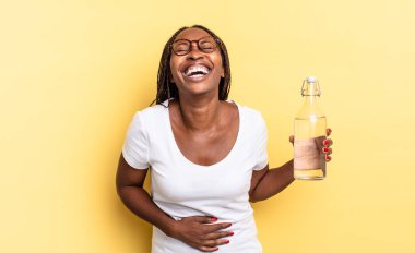 Komik bir şakaya yüksek sesle gülerek, mutlu ve neşeli hissederek, eğlenerek. su şişesi kavramı