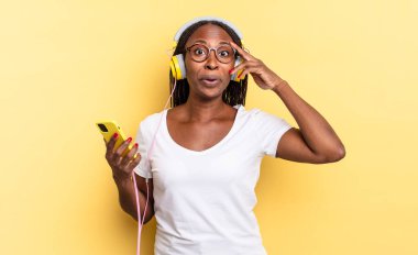 Mutlu, şaşkın ve şaşırmış görünüyor, gülümsüyor ve şaşırtıcı ve inanılmaz iyi haberleri fark ediyor ve müzik dinliyor.