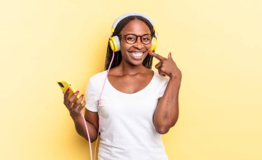 Kendi geniş gülüşüne, pozitif, rahat, tatmin olmuş tavrına ve müzik dinlediğine güvenerek gülümsüyor.