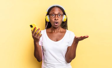 Son derece şok olmuş ve şaşırmış, endişeli ve panik içinde, stresli ve dehşete düşmüş bir bakışla ve müzik dinleyerek.