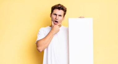 Ağzı ve gözleri sonuna kadar açık ve elleri çenesinde, hoş olmayan bir şokta, ne ya da vay canına diyor. boş tuval kavramı