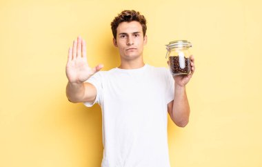 Ciddi görünüyor, sert, hoşnutsuz ve kızgın. Avuç içini açıp durmasını gösteriyor. kahve çekirdeği konsepti