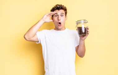 Mutlu, şaşkın ve şaşırmış görünüyor, gülümsüyor ve inanılmaz ve inanılmaz iyi haberleri fark ediyor. kahve çekirdeği konsepti