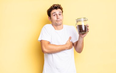 Omuz silkme, şaşkın ve kararsız hissetme, kolları çapraz ve şaşkın bakışlarla şüpheye düşme. kahve çekirdeği konsepti