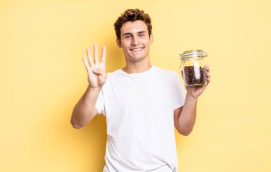 Gülümsüyor ve dost canlısı görünüyor, 4 ya da 4 numarayı gösteriyor, elle ileri doğru sayıyor, geri sayıyor. kahve çekirdeği konsepti