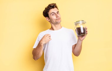 Kibirli, başarılı, pozitif ve gururlu görünüyor, kendini işaret ediyor. kahve çekirdeği konsepti