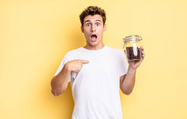 Şok olmuş ve ağzı açık, kendini işaret ederek şaşırmış görünüyordu. kahve çekirdeği konsepti