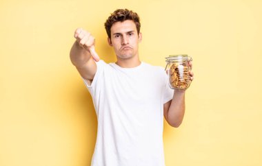 Kızgın, sinirli, hayal kırıklığına uğramış ya da hoşnutsuz, ciddi bir bakışla başparmaklarını aşağı gösteren. Ev yapımı kurabiye konsepti