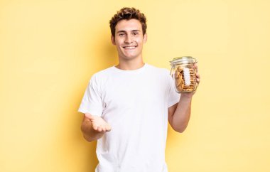 Mutlu bir şekilde gülümseyen, kendine güvenen, olumlu bakışlı, bir nesne ya da konsept sunan ve gösteren. Ev yapımı kurabiye konsepti