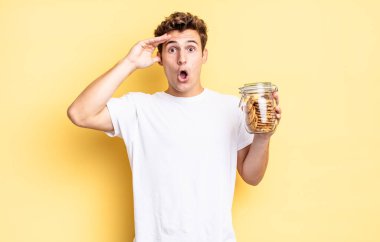 Mutlu, şaşkın ve şaşırmış görünüyor, gülümsüyor ve inanılmaz ve inanılmaz iyi haberleri fark ediyor. Ev yapımı kurabiye konsepti