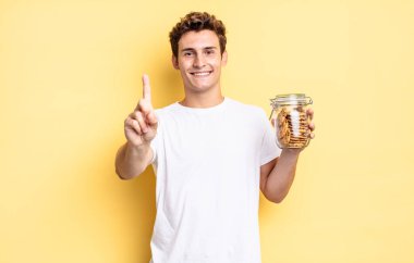 Gururla ve kendinden emin bir şekilde gülümseyerek bir numaralı pozu vererek, bir lider gibi hissederek. Ev yapımı kurabiye konsepti