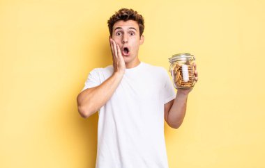 Şok olmuş ve korkmuş hissediyorum, ağzı açık ve elleri yanaklarında korkmuş görünüyor. Ev yapımı kurabiye konsepti