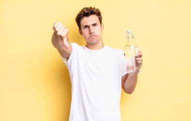 Kızgın, sinirli, hayal kırıklığına uğramış ya da hoşnutsuz, ciddi bir bakışla başparmaklarını aşağı gösteren. su şişesi kavramı