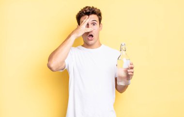 Şok olmuş, korkmuş ya da dehşete düşmüş gibi, yüzünüzü ellerinizle kapayıp parmaklarınızın arasına bakıyorsunuz. su şişesi kavramı