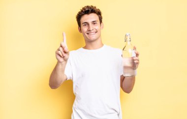 Gülümsüyor ve dost canlısı görünüyor, bir numara ya da ilk eli önde, geriye doğru sayıyor. su şişesi kavramı