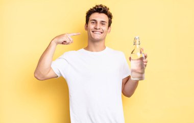 Kendi geniş gülüşüne, pozitif, rahat, tatmin olmuş tavrına güvenerek gülümsüyor. su şişesi kavramı