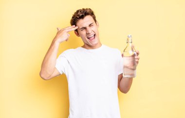 Mutsuz ve stresli görünüyor, intihar jesti elle silah işareti yapıyor, kafasını işaret ediyor. su şişesi kavramı