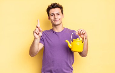 Gülümsüyor ve dost canlısı görünüyor, bir numara ya da ilk eli önde, geriye doğru sayıyor. çaydanlık konsepti