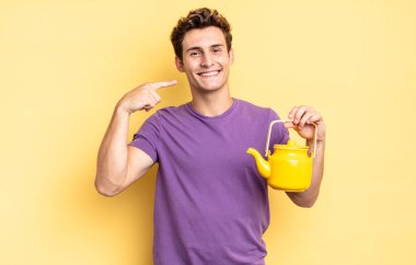 Kendi geniş gülüşüne, pozitif, rahat, tatmin olmuş tavrına güvenerek gülümsüyor. çaydanlık konsepti