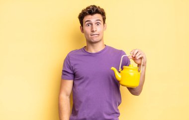 Şaşırmış ve kafası karışmış görünüyor, sinirsel bir hareketle dudağını ısırıyor, sorunun cevabını bilmiyor. çaydanlık konsepti