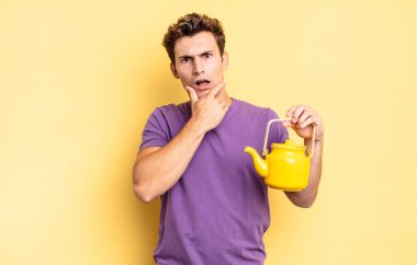 Ağzı ve gözleri sonuna kadar açık ve elleri çenesinde, hoş olmayan bir şokta, ne ya da vay canına diyor. çaydanlık konsepti