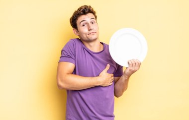 Omuz silkme, şaşkın ve kararsız hissetme, kolları çapraz ve şaşkın bakışlarla şüpheye düşme. boş tabak kavramı