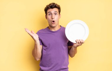 Şaşırmış ve şoke olmuş bir halde, çenesi düşmüş ve eli açık bir objeyi tutuyordu. boş tabak kavramı