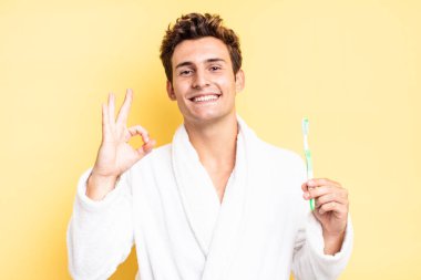 Mutlu, rahat ve tatmin olmuş hissediyorum. Onayını iyi bir hareketle gösteriyorum. Gülümsüyorum. diş fırçası konsepti